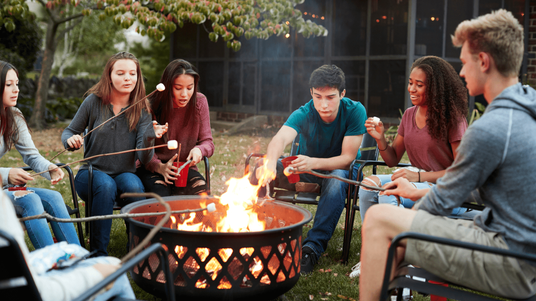 friends roasting marshmallow in the fire pit
