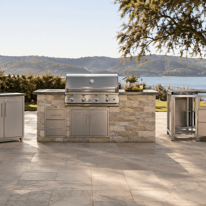 Standalone stainless steel cabinets, a stone-clad built-in grill island, and a bare metal frame kit side by side on a lakeside patio