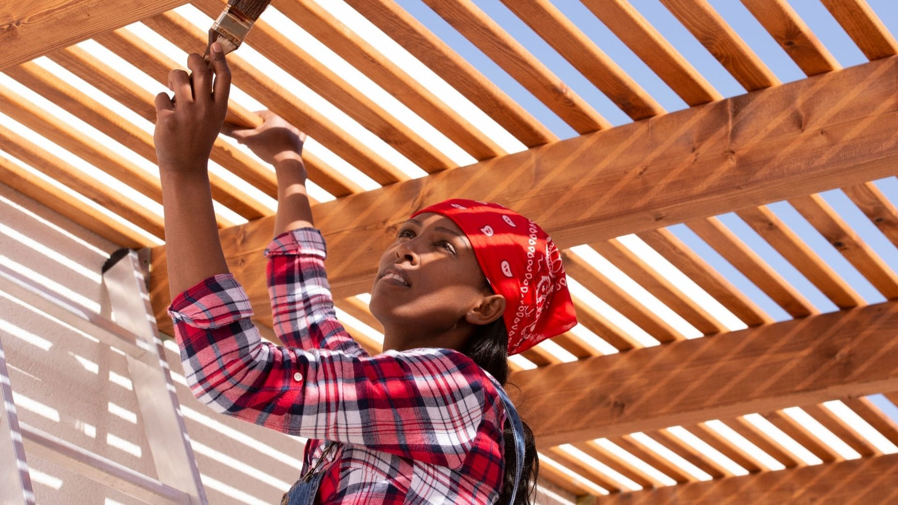 woman painting her pergola