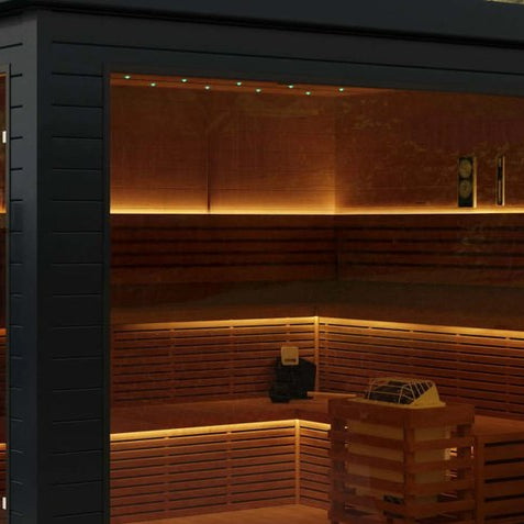 Black Aleko Camellia outdoor sauna with glass wall and lit cedar benches on a patio