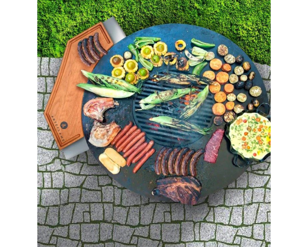 Arteflame Cherry Wood Cutting Board on Arteflame Grill overhead view with sausages, ribs, corn, and vegetables grilling