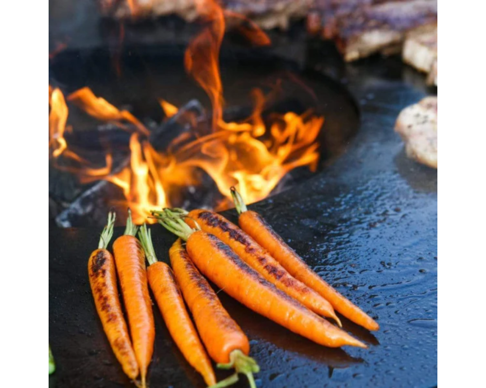 Arteflame Classic 40" Grill flat-top carbon steel surface char-grilling whole carrots over open center flame