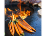 Arteflame Classic 40" Grill flat-top carbon steel surface char-grilling whole carrots over open center flame