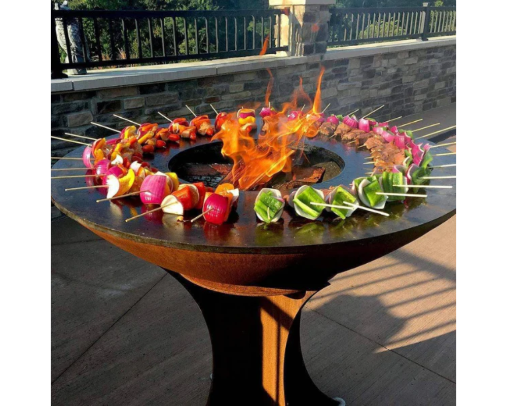 Arteflame Classic 40" Grill with Tall Euro Base grilling colorful vegetable and meat skewers around open center flame