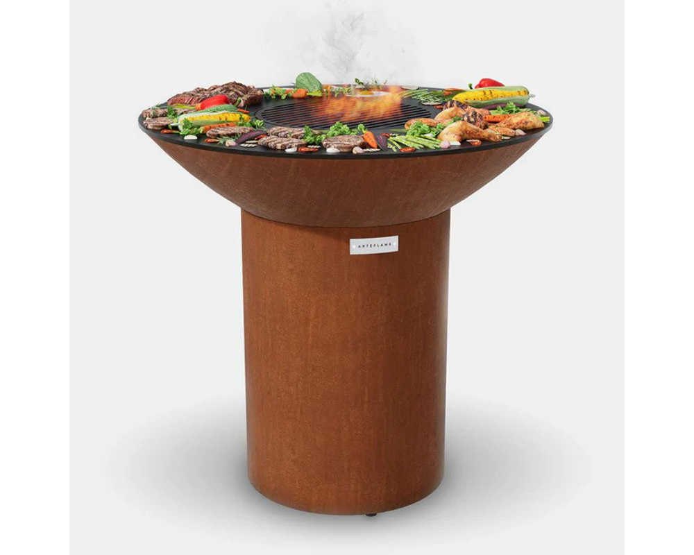 Arteflame Classic 40" Corten Steel Grill with Tall Round Base grilling steaks, chicken, and vegetables on flat-top surface