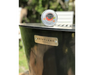 Crisbee Puck grill seasoning tin placed on Arteflame Made in USA black steel fire pit grill flat-top surface