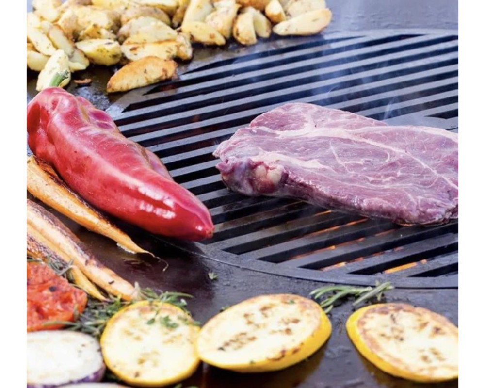 Arteflame Carbon Steel Grill Grate Insert with steak, red pepper, carrots, tomatoes, and zucchini on flat-top surface
