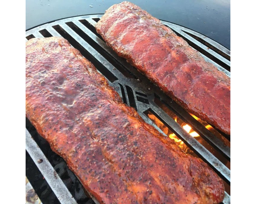 Arteflame Carbon Steel Center Grill Grate Insert grilling two full racks of seasoned BBQ pork ribs over open flame