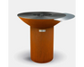 Arteflame round outdoor grill with dark steel cooktop, side shelf, center grate, and cylindrical corten steel base