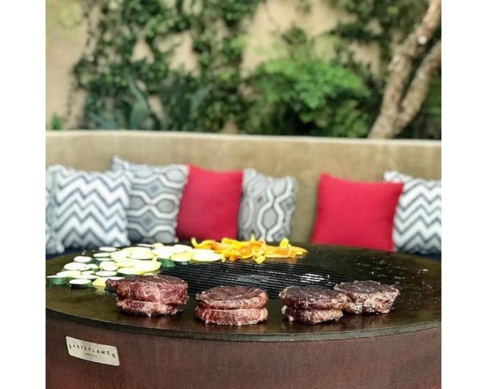 Arteflame One Series 30" Grill flat-top steel surface searing filet mignon steaks and zucchini on outdoor patio