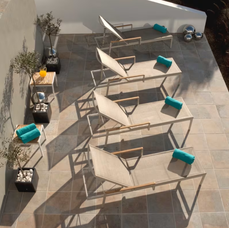 Barlow Tyrie Aura sling chaise lounge champagne frame titanium sling outdoor patio aerial view multiple units arranged
