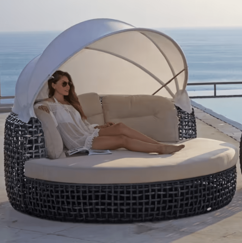 woman relaxing inside the dyanasty wicker outdoor bed