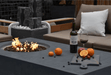 Elementi Metropolis rectangular fire pit table with flames lit outdoors