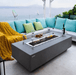 Elementi Granville rectangular fire pit table with flames lit outdoors