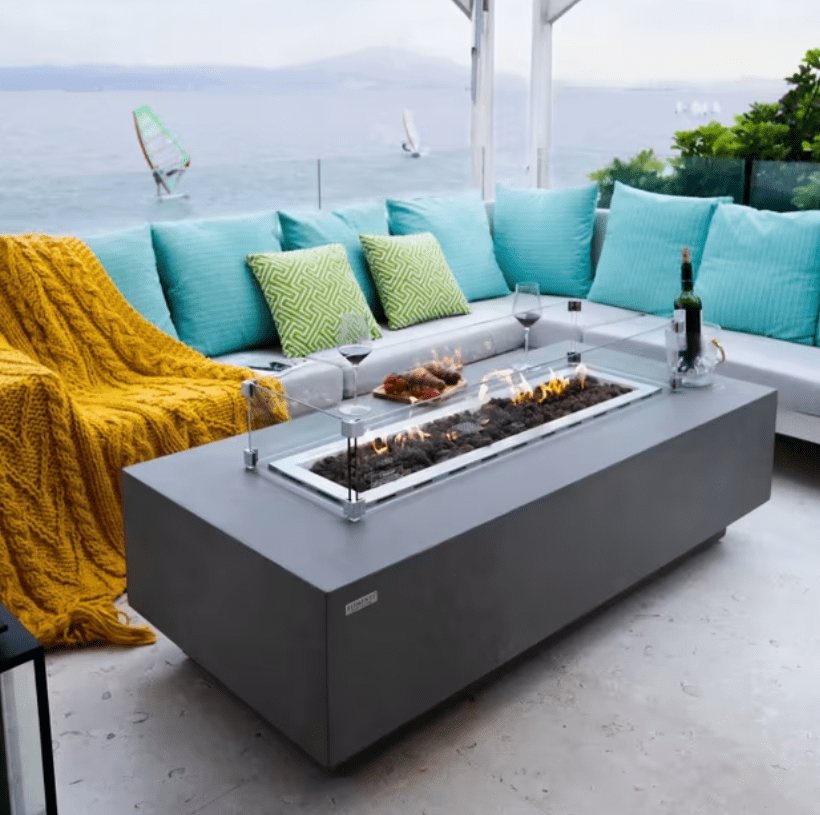 Elementi Granville rectangular fire pit table with flames lit outdoors