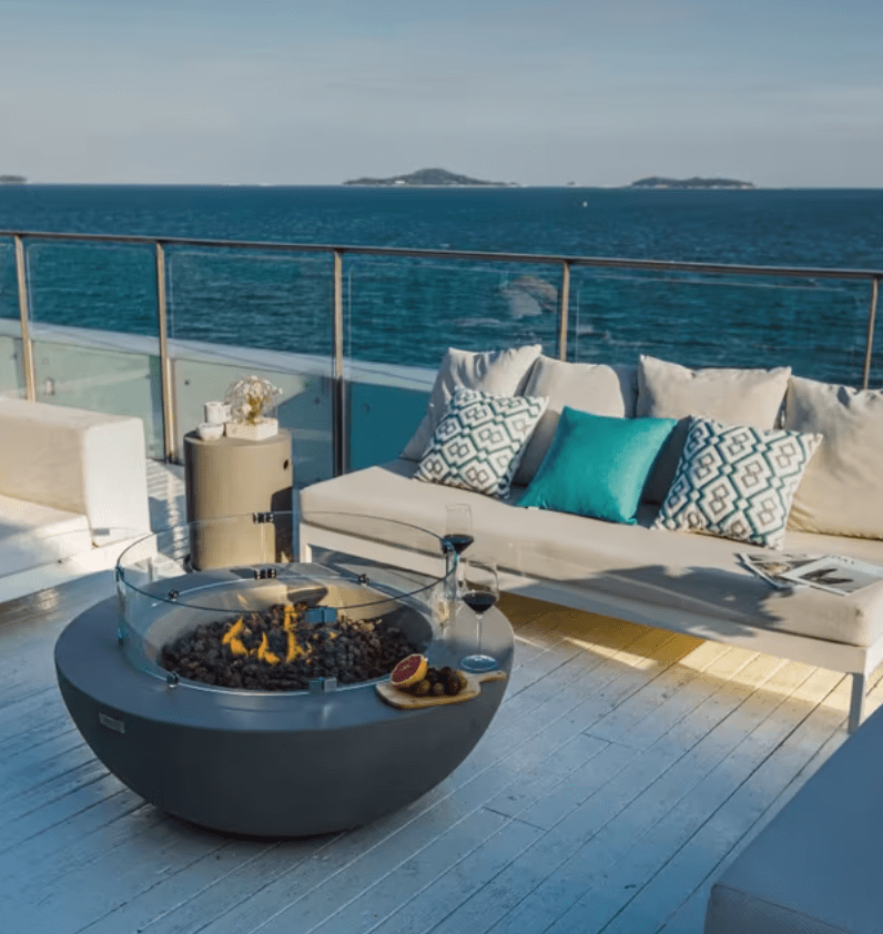 Elementi Lunar Bowl round concrete fire pit with flames lit