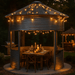 Grain bin gazebo with string lights and candlelit dining setup — a stunning evening outdoor space for STR hosts