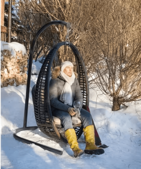 man resting in the heri hanging chair during winter