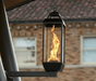 Travis Industries Tempest gas lantern on deck post mount with vortex flame burning on residential patio
