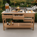 POVL Outdoor Calera teak buffet table styled for outdoor entertaining with food drinks and fire pit