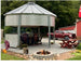Sioux Steel grain bin gazebo with outdoor dining, fire pit, and string lights — perfect gathering spot for Airbnb and STR properties
