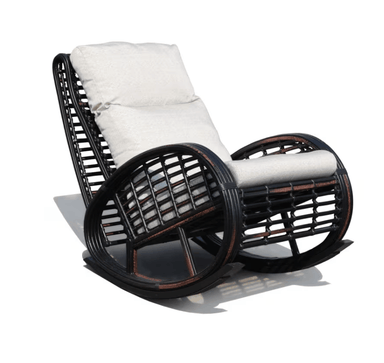 A dark brown wicker rocking chair with plush off-white cushions, shown from a three-quarters angle on a white background with a soft shadow.