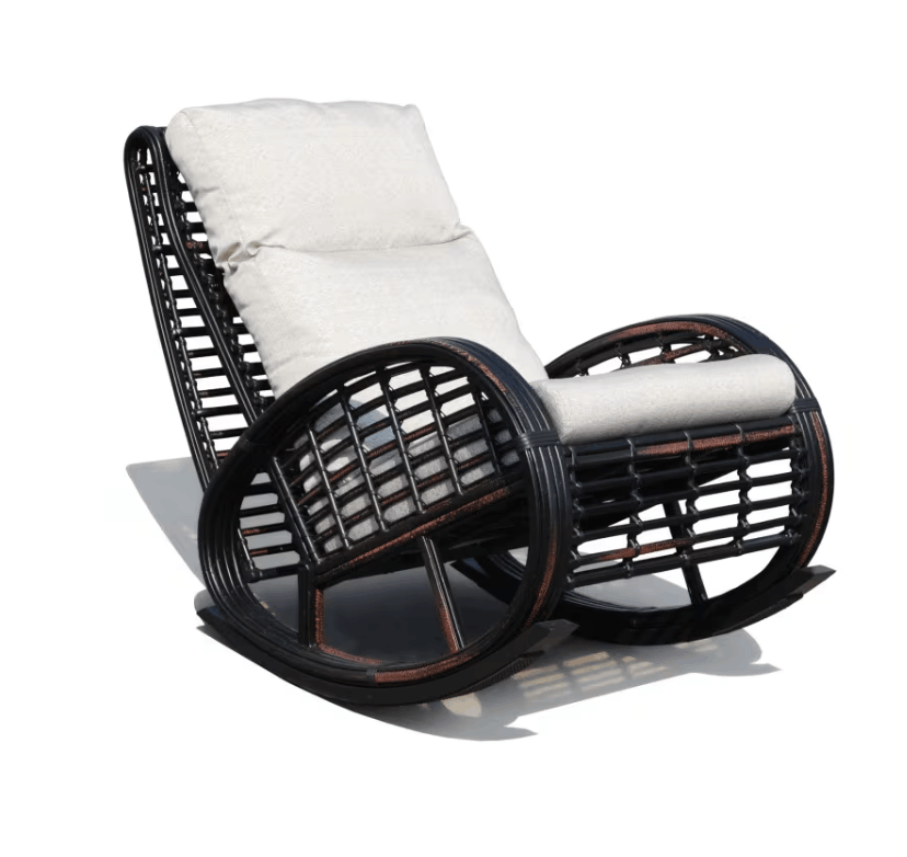 A dark brown wicker rocking chair with plush off-white cushions, shown from a three-quarters angle on a white background with a soft shadow.