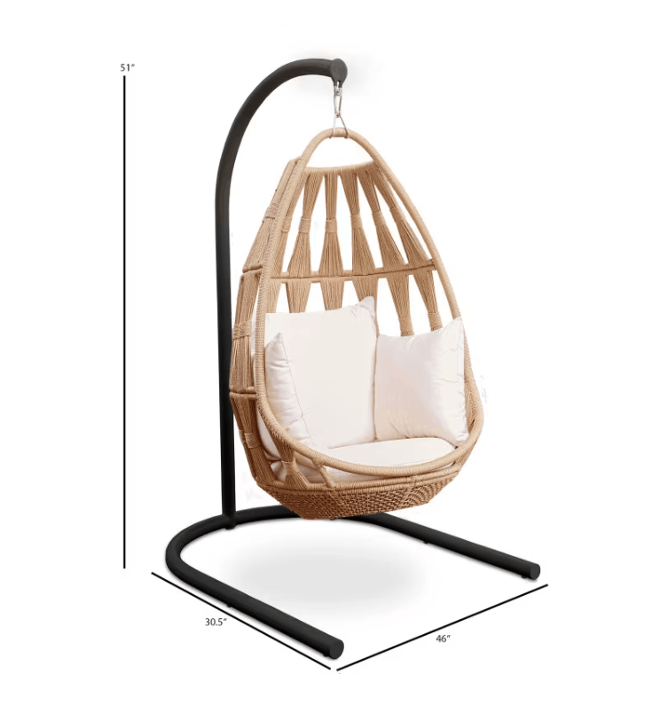 A hanging wicker egg chair with a natural beige woven body, cream cushions, and a black metal stand, shown with dimension lines indicating 55 inches height, 30.5 inches width, and 46 inches depth on a white background.