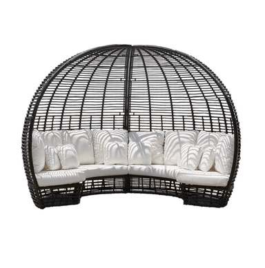 A black wicker outdoor daybed with a curved, dome-like structure and thick white cushions, shown against a plain white background.