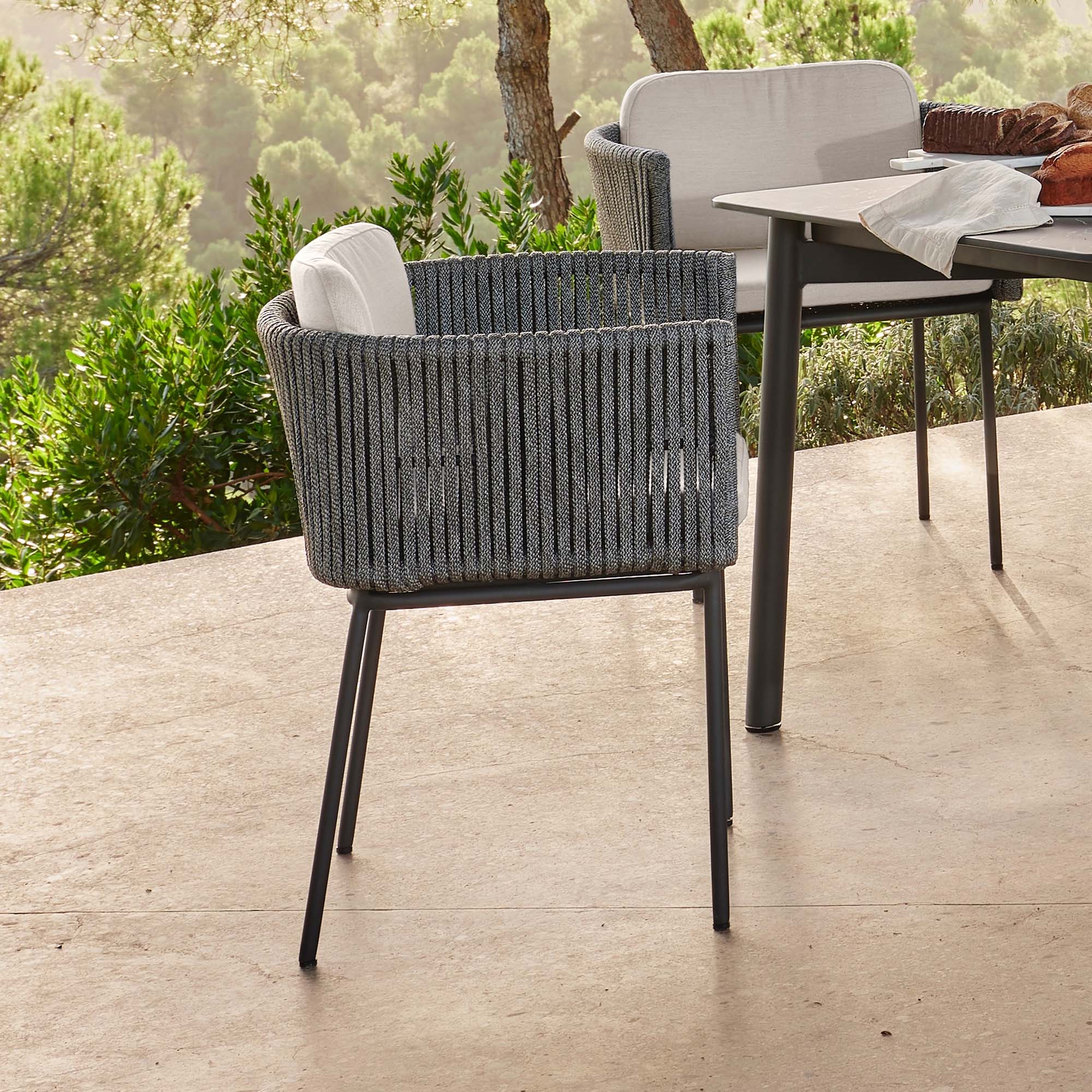 Gray woven chair on a wooden deck with a blurred outdoor setting