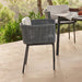Gray woven chair on a wooden deck with a blurred outdoor setting