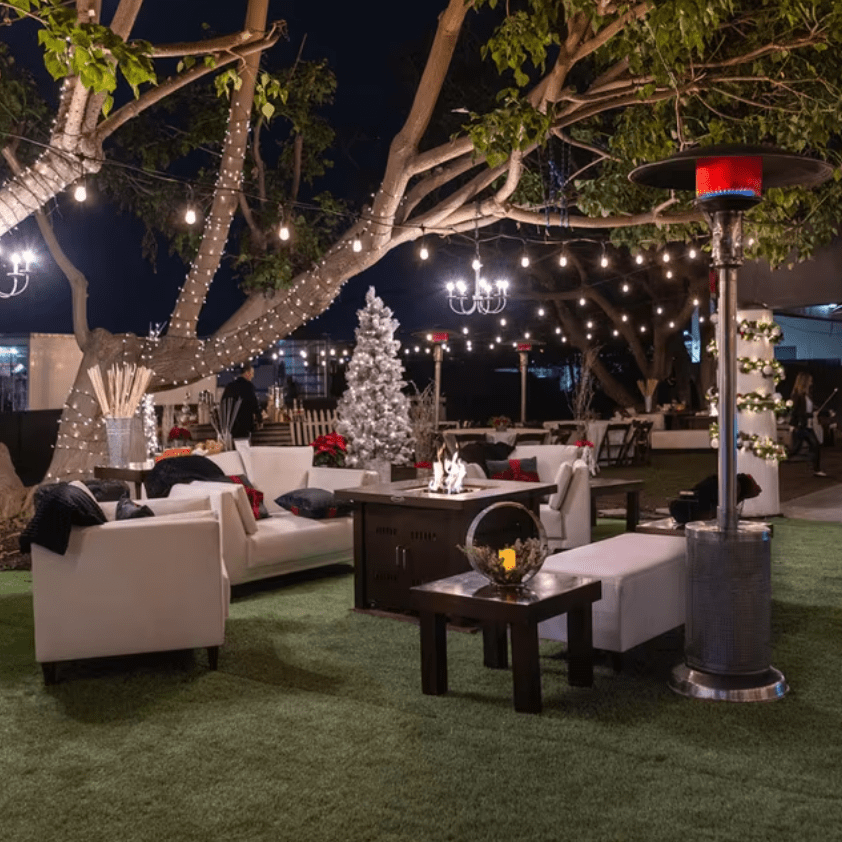 Sunglo propane patio heater in use outdoor evening lounge with string lights fire pit and seating