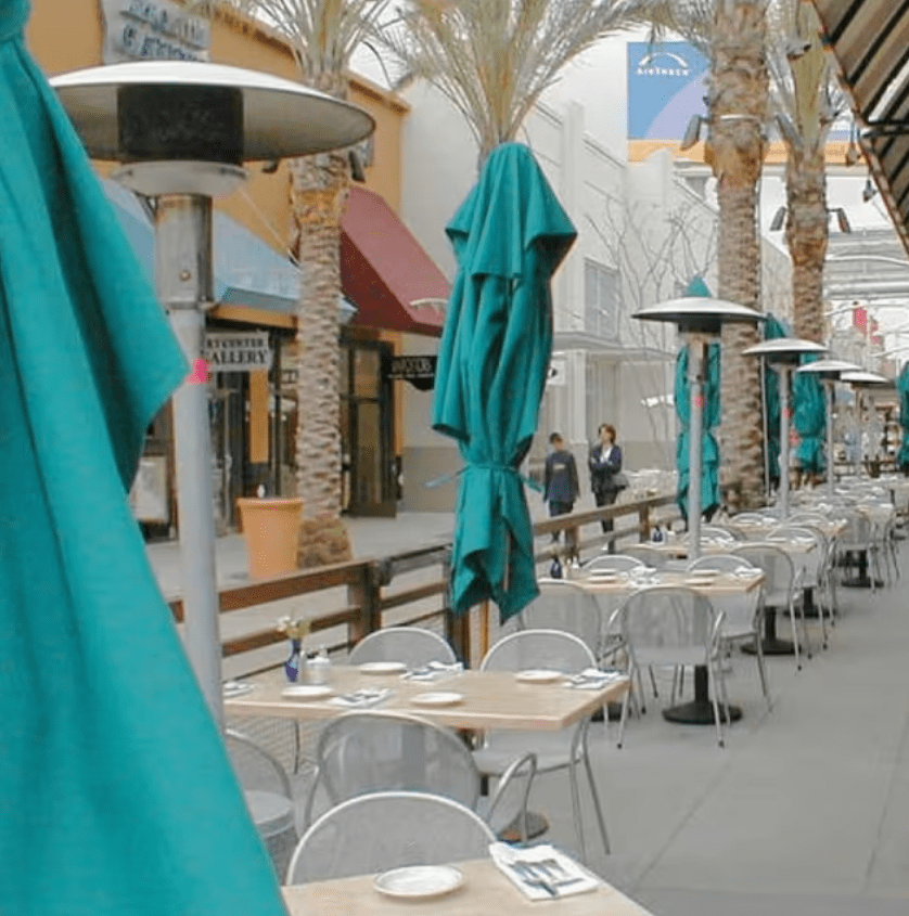 Sunglo freestanding propane patio heaters in use commercial outdoor dining patio with umbrellas and tables