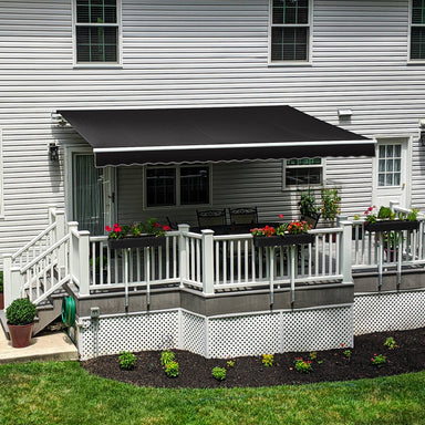 Black Awntech Maui motorized retractable awning extended over a white railed deck with a dining table and flower boxes