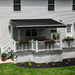 Black Awntech Maui motorized retractable awning extended over a white railed deck with a dining table and flower boxes