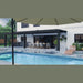 Equinox pergola with louvers closed in heavy rain, keeping the patio dining area and outdoor kitchen covered