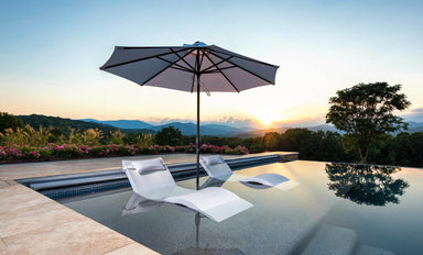 Ledge Lounger Essential pool umbrella shown in an outdoor setting, lifestyle photo 1 of 7