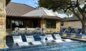 Ledge Lounger Essential pool umbrella shown in an outdoor setting, lifestyle photo 2 of 7
