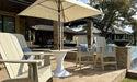 Ledge Lounger Essential pool umbrella shown in an outdoor setting, lifestyle photo 3 of 7