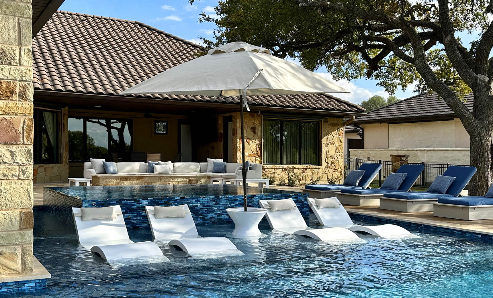 Ledge Lounger Essential pool umbrella shown in an outdoor setting, lifestyle photo 1 of 7