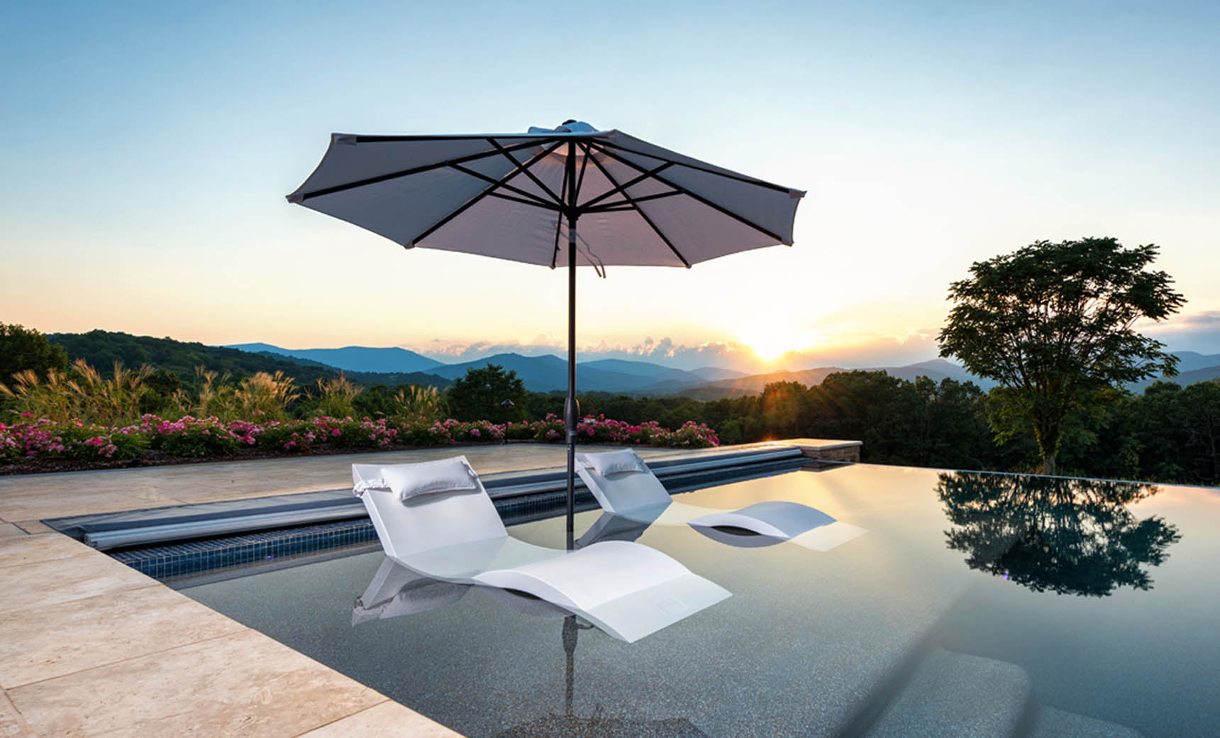 Ledge Lounger Essential pool umbrella shown in an outdoor setting, lifestyle photo 3 of 7