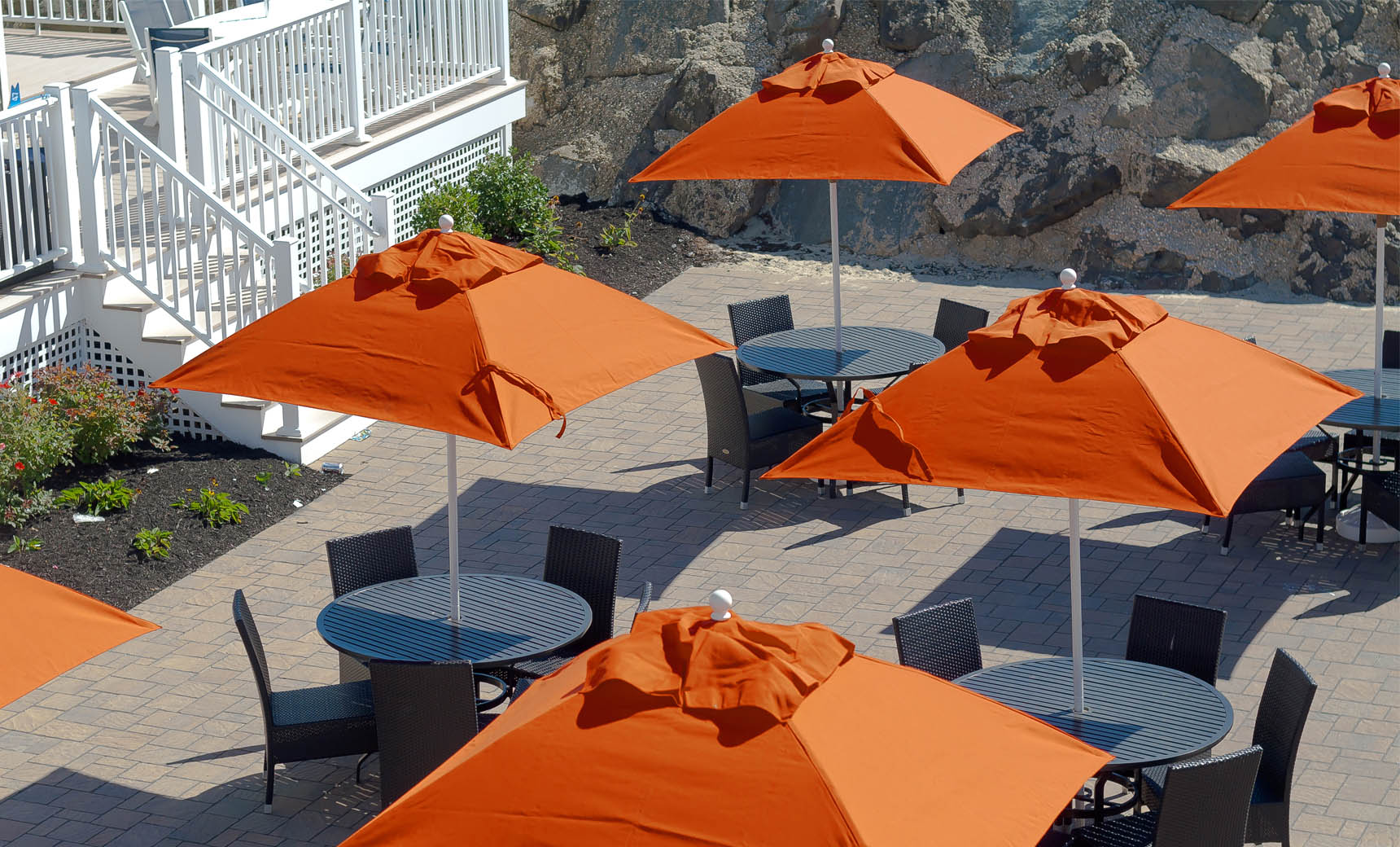 Ledge Lounger Essential pool umbrella shown in an outdoor setting, lifestyle photo 7 of 7