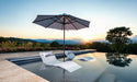 Ledge Lounger Essential pool umbrella shown in an outdoor setting, lifestyle photo 3 of 7
