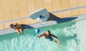 Overhead view of a man in the pool shooting a ball at the Hoopstr poolside basketball hoop while a woman watches from the edge