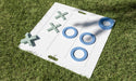 Giant white tic tac toe board with blue Os and green Xs on the grass, three Os lined up across the middle row