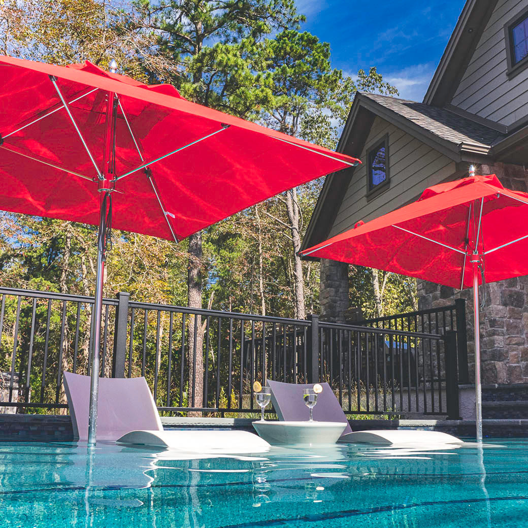 Ledge Lounger Premier pool umbrella shown in an outdoor setting, lifestyle photo 1 of 4