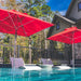 Ledge Lounger Premier pool umbrella shown in an outdoor setting, lifestyle photo 1 of 4