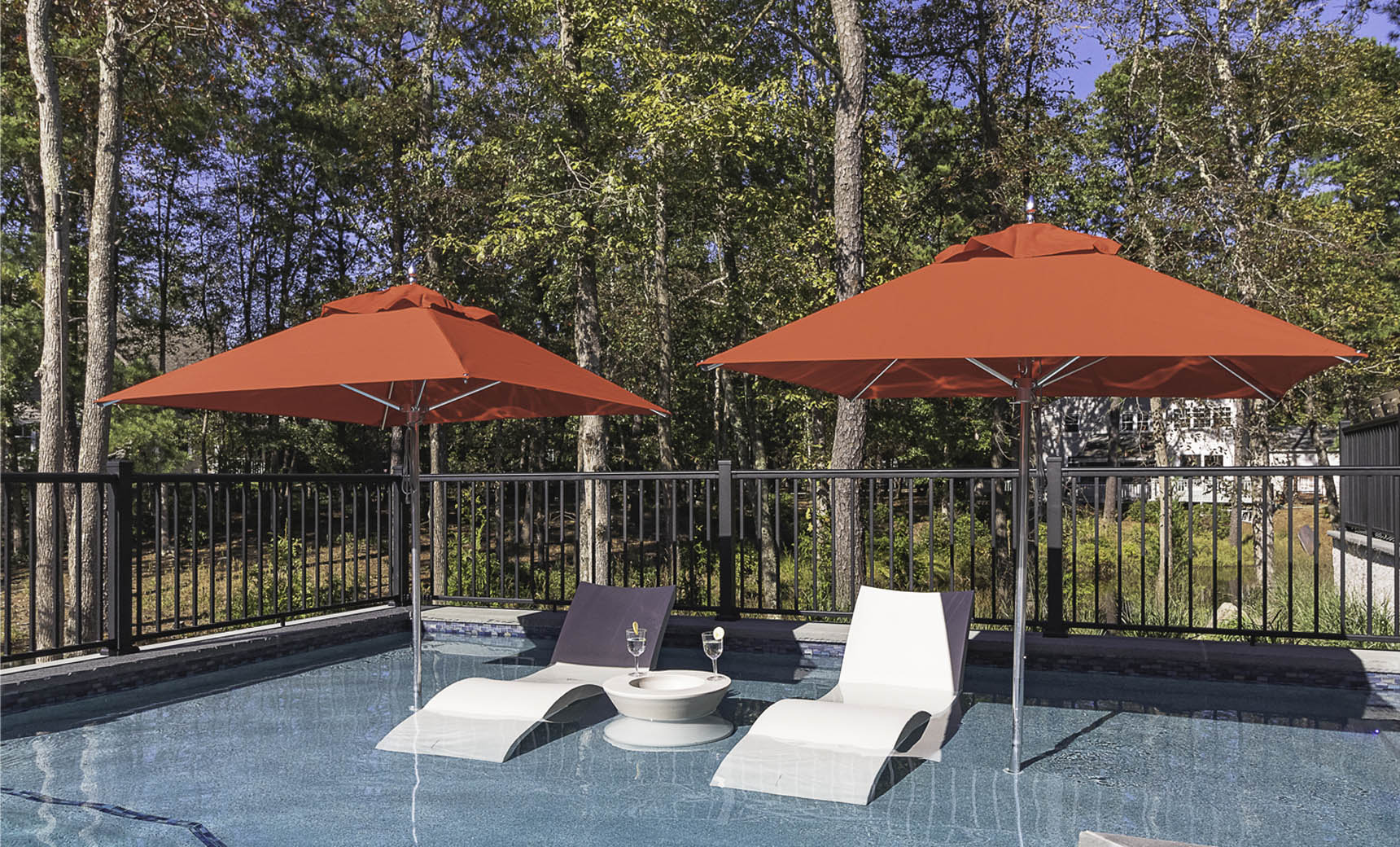 Ledge Lounger Premier pool umbrella shown in an outdoor setting, lifestyle photo 1 of 4