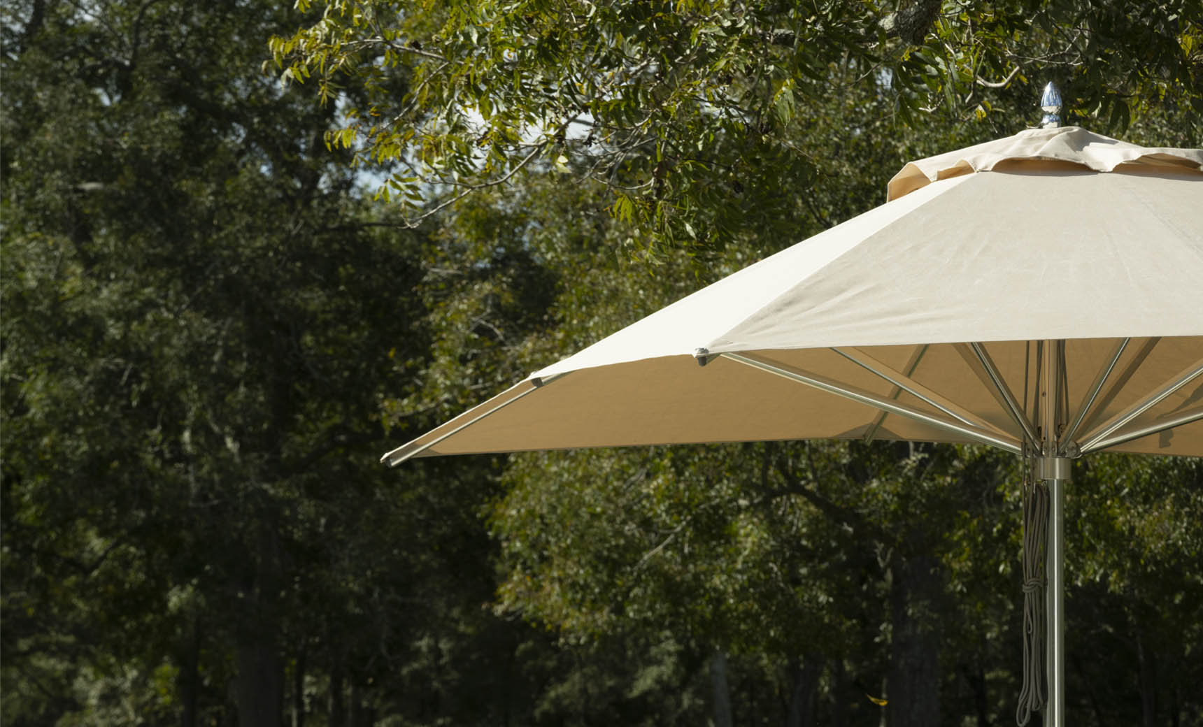 Ledge Lounger Premier pool umbrella shown in an outdoor setting, lifestyle photo 4 of 4